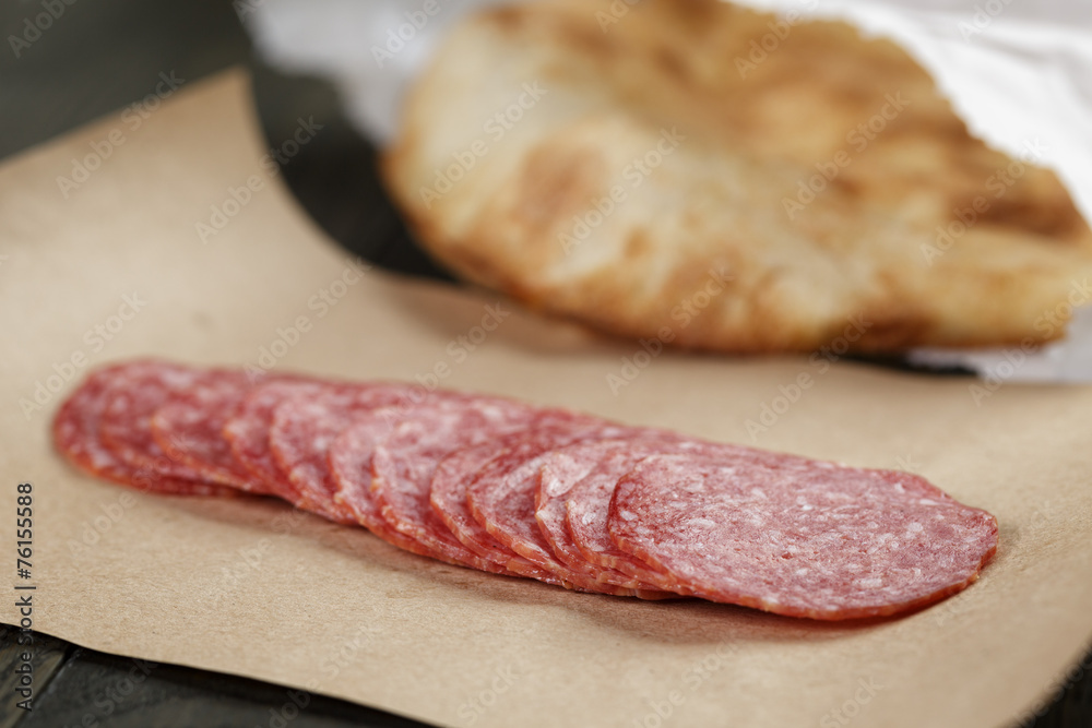 dried salami sausage on paper ready for sandwich dried salami sausage on paper ready for sandwich