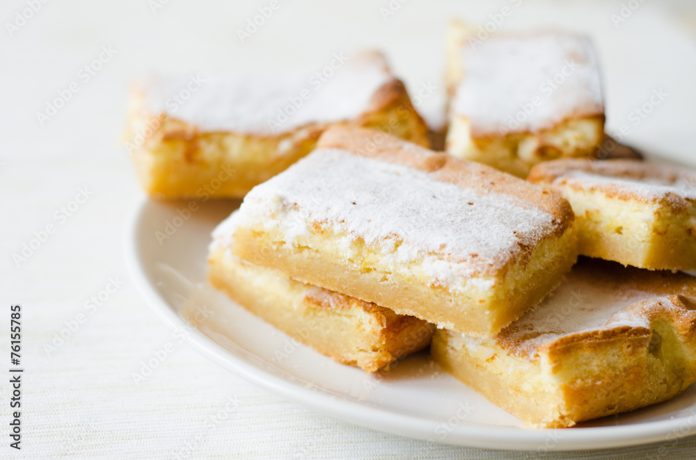 lemon bars sprinkled with powdered sugar white plate lemon bars sprinkled with powdered sugar white plate