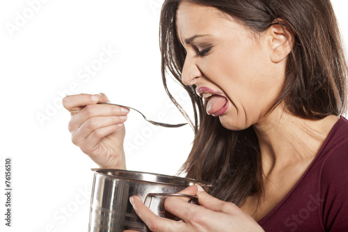 scowling young woman is disgusted by the smell of her food photo