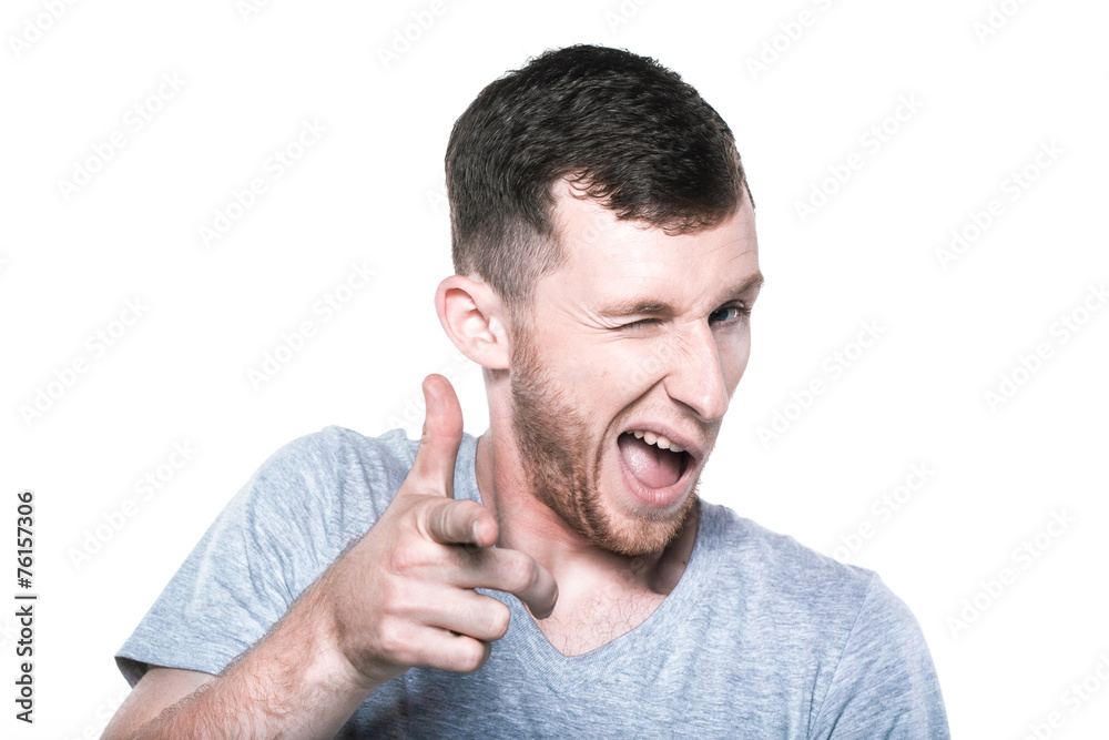 Winking young man pointing his finger to you Winking young man pointing his finger to you