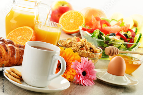Breakfast with coffee, juice, croissant, salad, muesli and egg