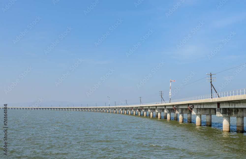 Railway bridge lead across the lake in Thailand