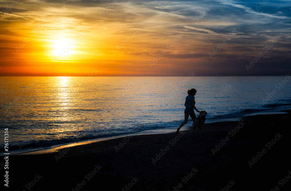 Girl runs with the dog on the beach