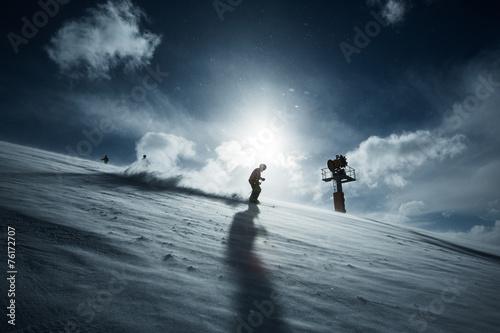Tableau sur toile Skifahrer bei Gegenlicht vor Schneekanone