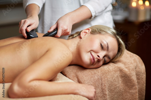 close up of woman having hot stone massage in spa