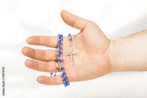 Male hand holding blue beads rosary