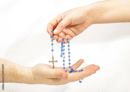Female hand sharing rosary with male hand