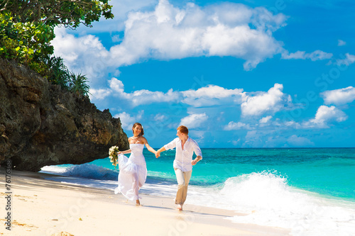 Photography happy bride and groom having fun on a tropical beach
