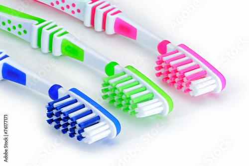 Blue, green, pink toothbrushes isolated on white background