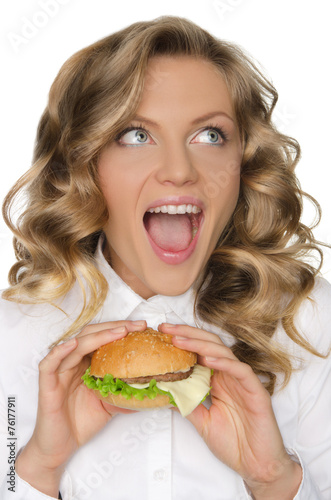 young woman with hamburger looking away