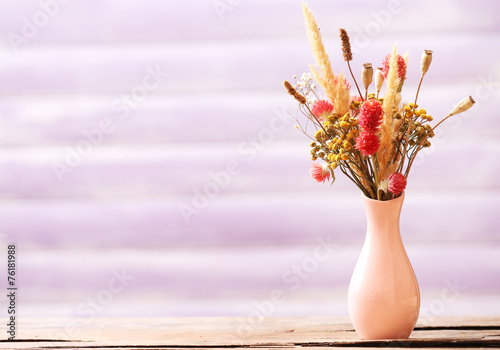Fototapeta Naklejka Na Ścianę i Meble -  Bouquet of dried flowers in vase on color planks background
