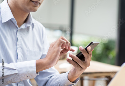 Canvas Print Indian businessman using smartphone while having lunch