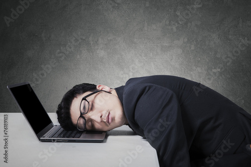 Exhausted businessman sleeping on his laptop photo