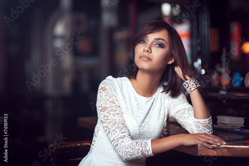 Beautiful girl in white dress in cafe