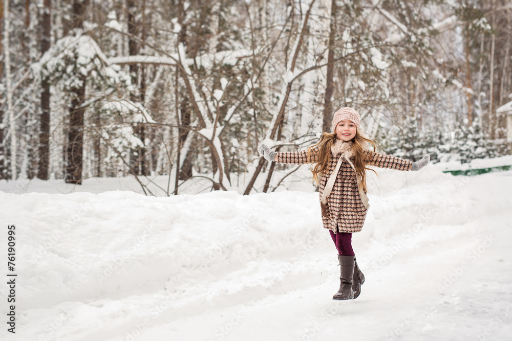 Girl happily runs in winter woods