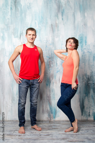 Young couple posing near the colorful wall