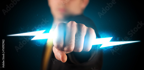 Business man holding glowing lightning bolt in his hands