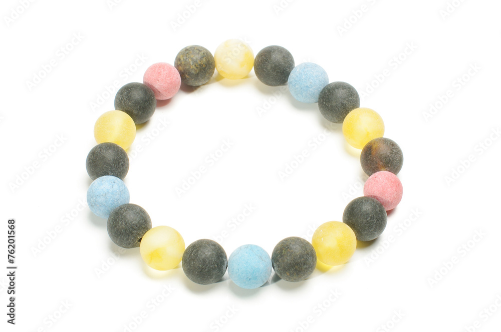 Multicolor yellow black and blue amber beads armlet isolated Multicolor yellow black and blue amber beads armlet isolated