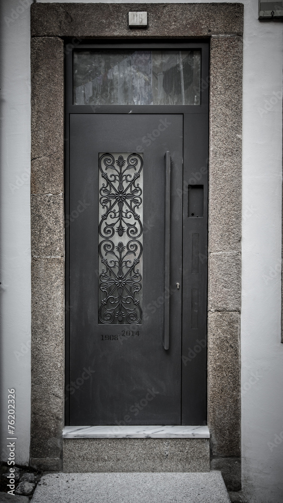 Metal door with patterns on the stone wall. Toned Metal door with patterns on the stone wall. Toned