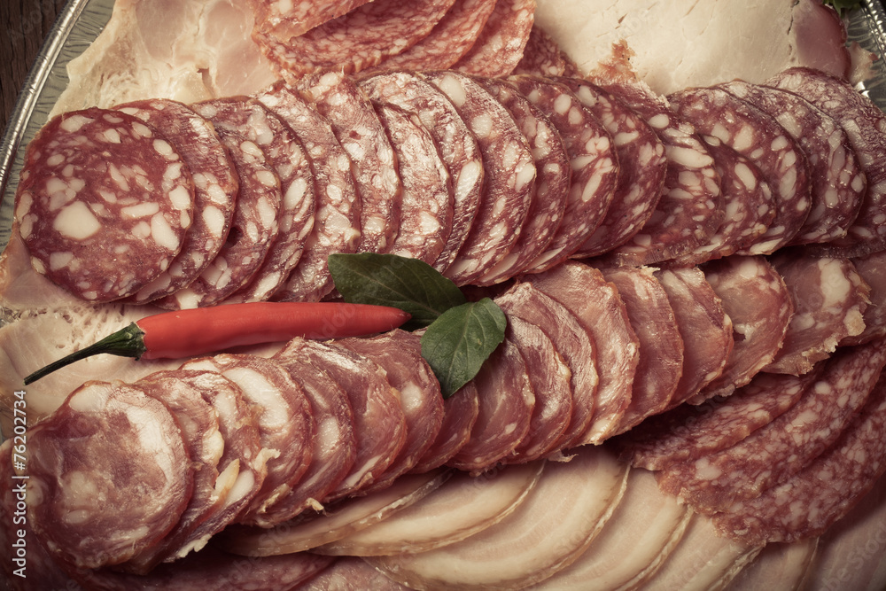 Plate with different kinds of sliced sausage and red hot chilli Plate with different kinds of sliced sausage and red hot chilli