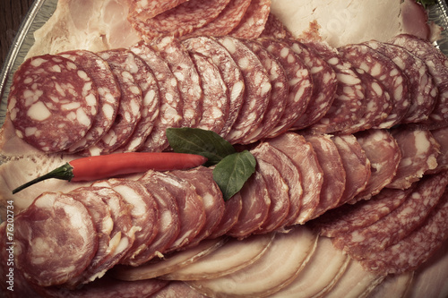 Plate with different kinds of sliced sausage and red hot chilli