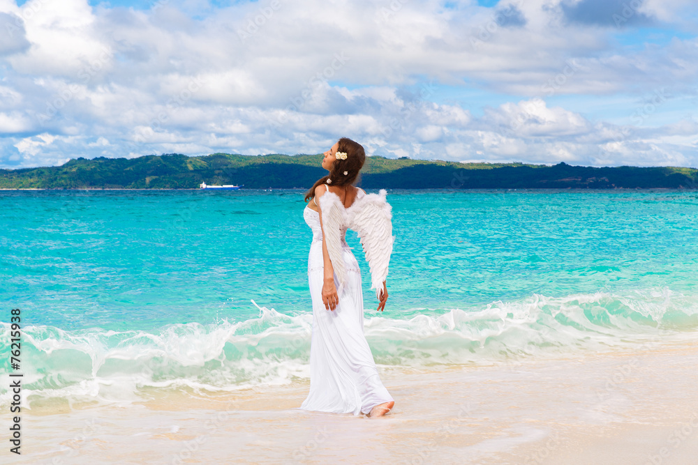 Beautiful young bride with angel wings on the sea coast. Tropica Beautiful young bride with angel wings on the sea coast. Tropica
