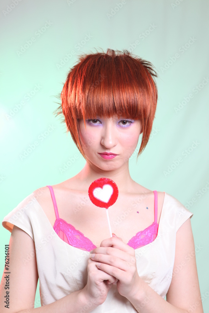 Girl with candy heart with red hair in white dress