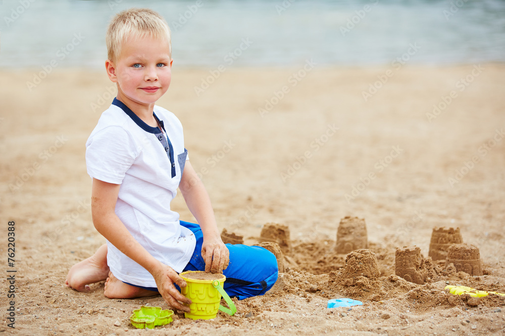 Kind baut Sandburg am Strand Kind baut Sandburg am Strand