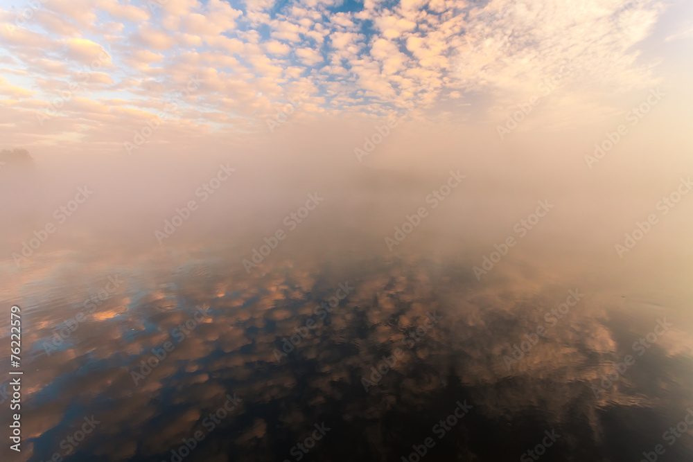 misty morning on the river and clouds reflected in water