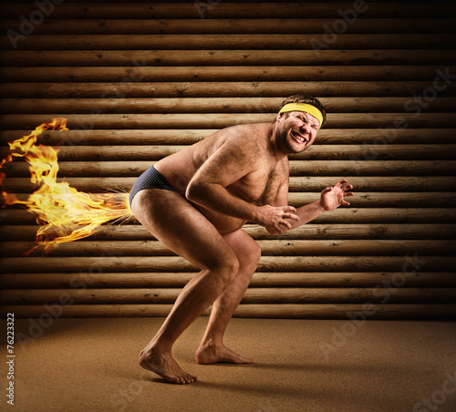 Very strange naked man farts by fire