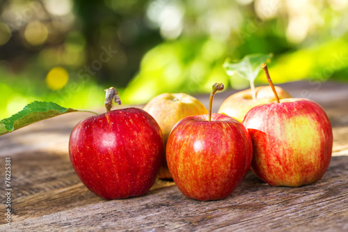 Ripe apples on wooden table, on nature background