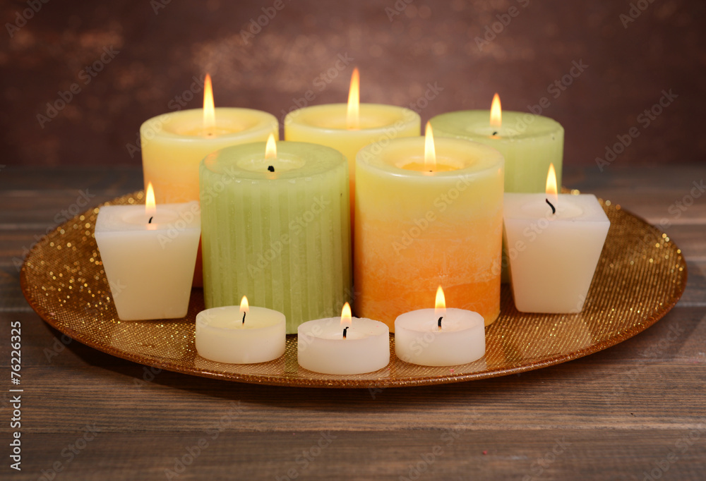 Beautiful candles on table on brown background Beautiful candles on table on brown background