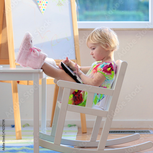 Little girl using tablet pc at home