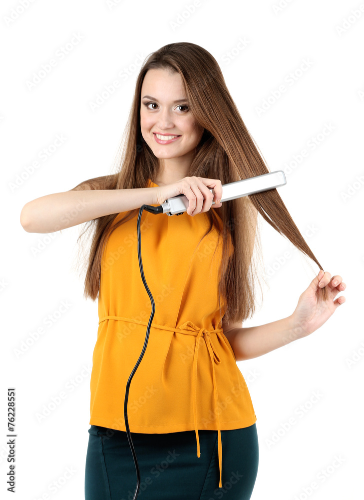 Beautiful young woman with long hair using hair straighteners Beautiful young woman with long hair using hair straighteners