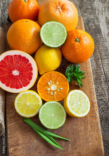 Halves of fresh citrus fruits on wooden background. Orange, grap