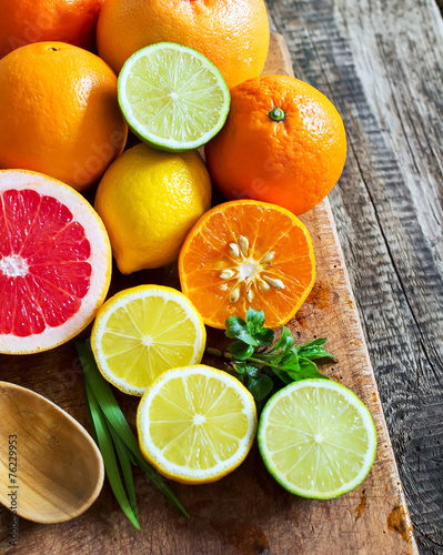 Fototapeta Naklejka Na Ścianę i Meble -  Halves of fresh citrus fruits on wooden background. Orange, grap