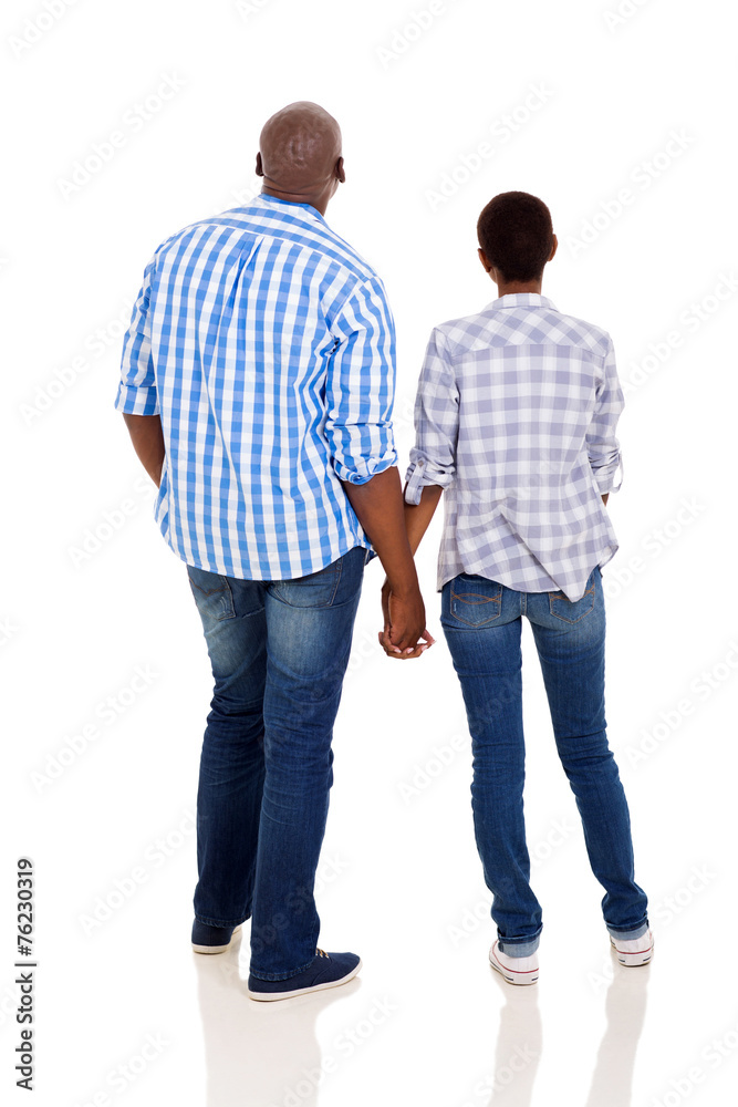 rear view of young african couple holding hands rear view of young african couple holding hands