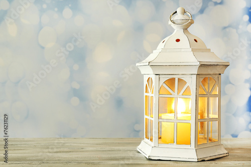 Lantern on wooden surface and blurred background © Africa Studio
