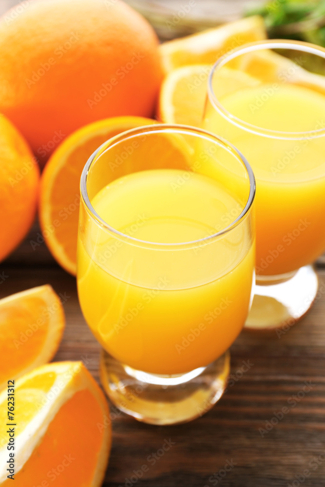Glass of orange juice and slices on wooden table background Glass of orange juice and slices on wooden table background