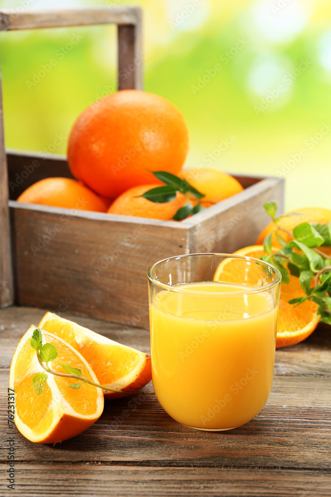 Glass of orange juice with crate of oranges and slices Glass of orange juice with crate of oranges and slices
