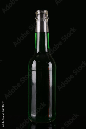 Colorful alcoholic beverages in glass bottle on dark background