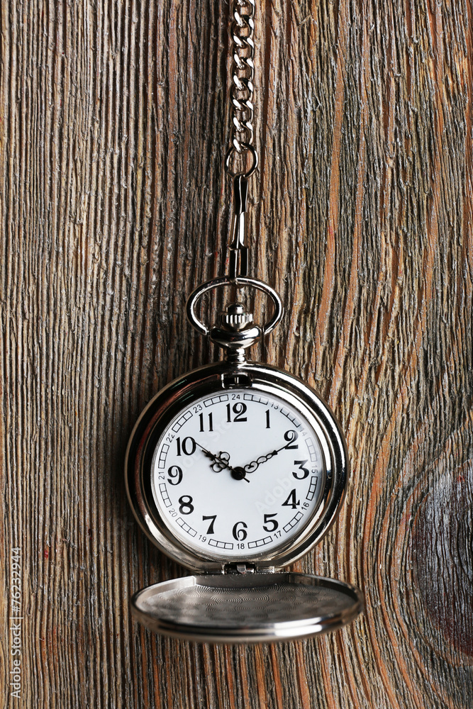 Silver pocket clock on wooden background Silver pocket clock on wooden background