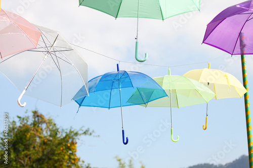Colorful of umbrellas hang on the sky with blue sky background