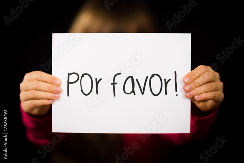 Child holding sign with Spanish words Por Favor - Please