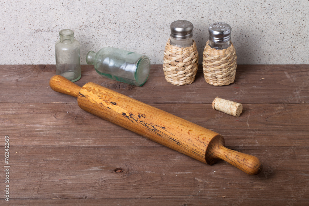 Salt, pepper, rolling pin, old bottles and cork on the old woode