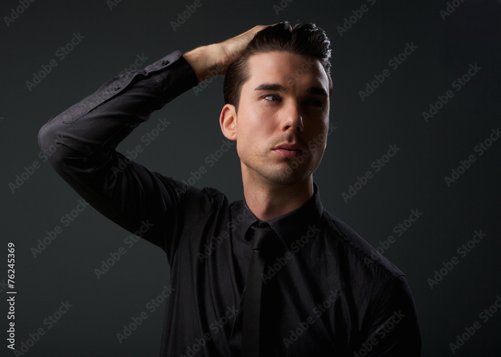 Attractive young man with hand in hair