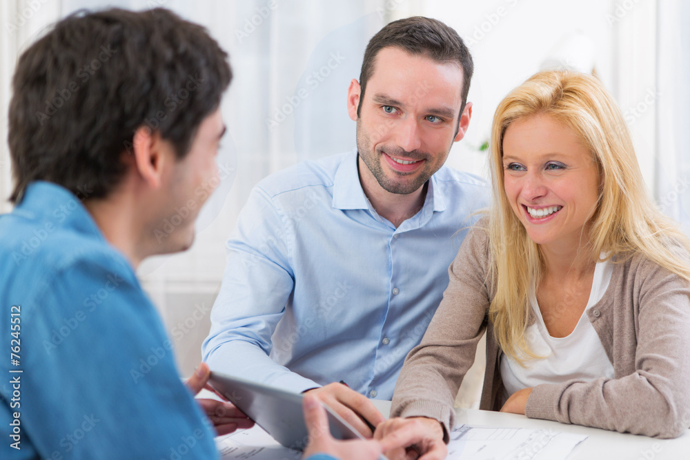 Young attractive couple signing contract on tablet Young attractive couple signing contract on tablet