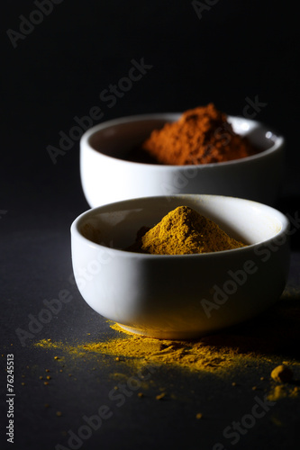 Spices in cups on a black background