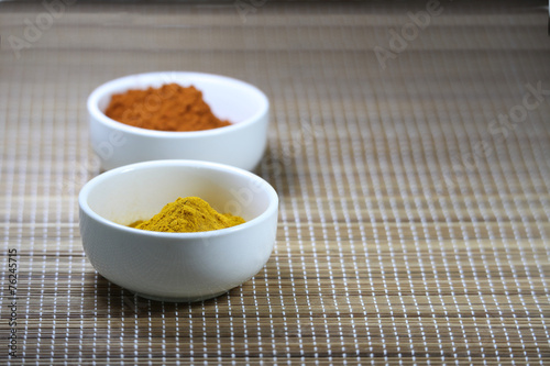 Spices in cups on a mat background