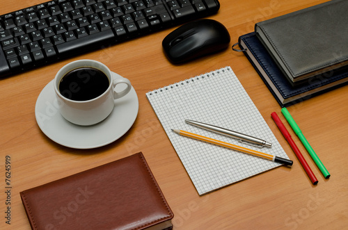 keyboard, cup of coffee and office supplies